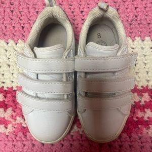 White Velcro sneakers with grey detailing on the heels